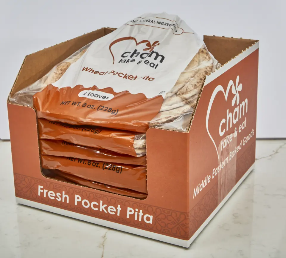 A Cham Bakery display case filled with bags of whole wheat pocket pita