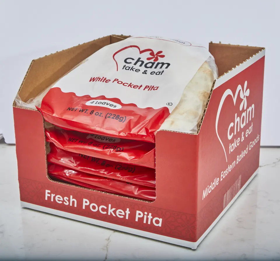 A red Cham Bakery shelf case pulled open, bags of White Pocket Pita stacked inside ready for the shelf
