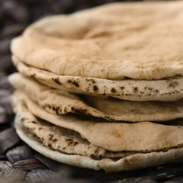 A pile of soft pocket pita, toasted in spots by the oven