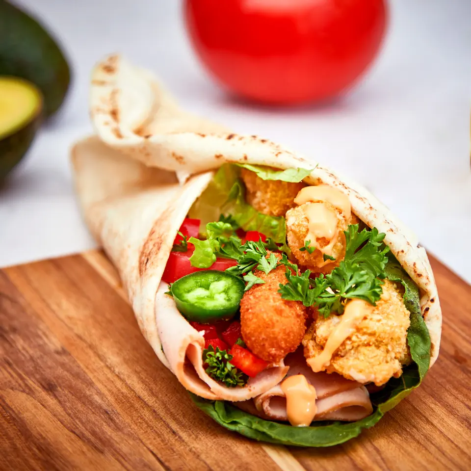 A pita rolled around a filling of chicken and vegetables