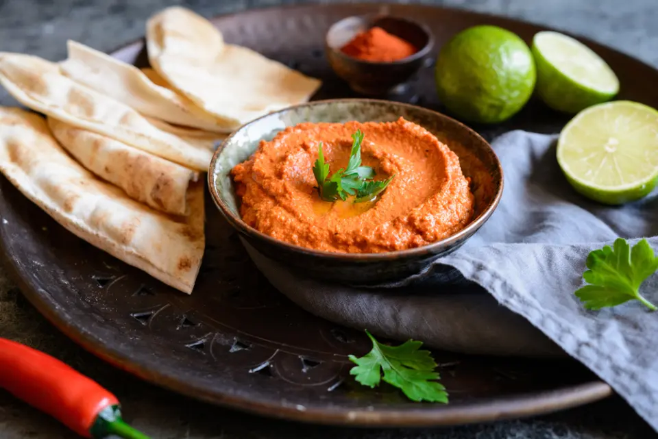 Pita chips around a bowl of dip