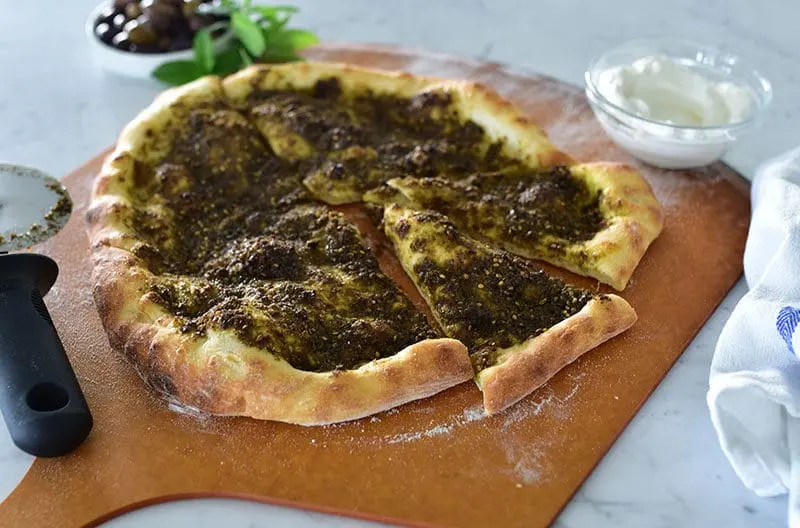 Za'atar bread cut into wedges on a board