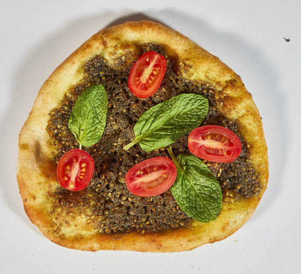 Za'atar bread topped with cherry tomatoes and mint leaves